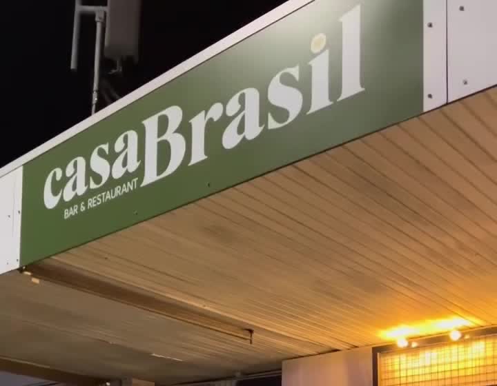 The Casa Brasil entrance sign lit up at night on Thomas Drive, Chevron Island